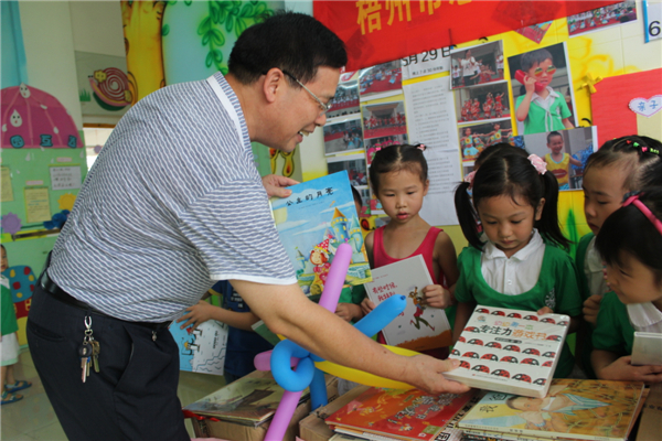 梧州市總工會黨組書記、常務副主席朱明勝在梧州市總工會到梧州高新區(qū)雙語實驗學校開展關愛農(nóng)民工留守活動中為孩子們送上學習用具